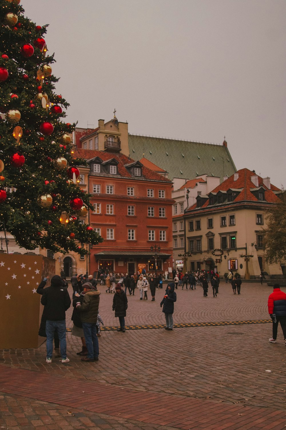 a group of people standing around a christmas tree