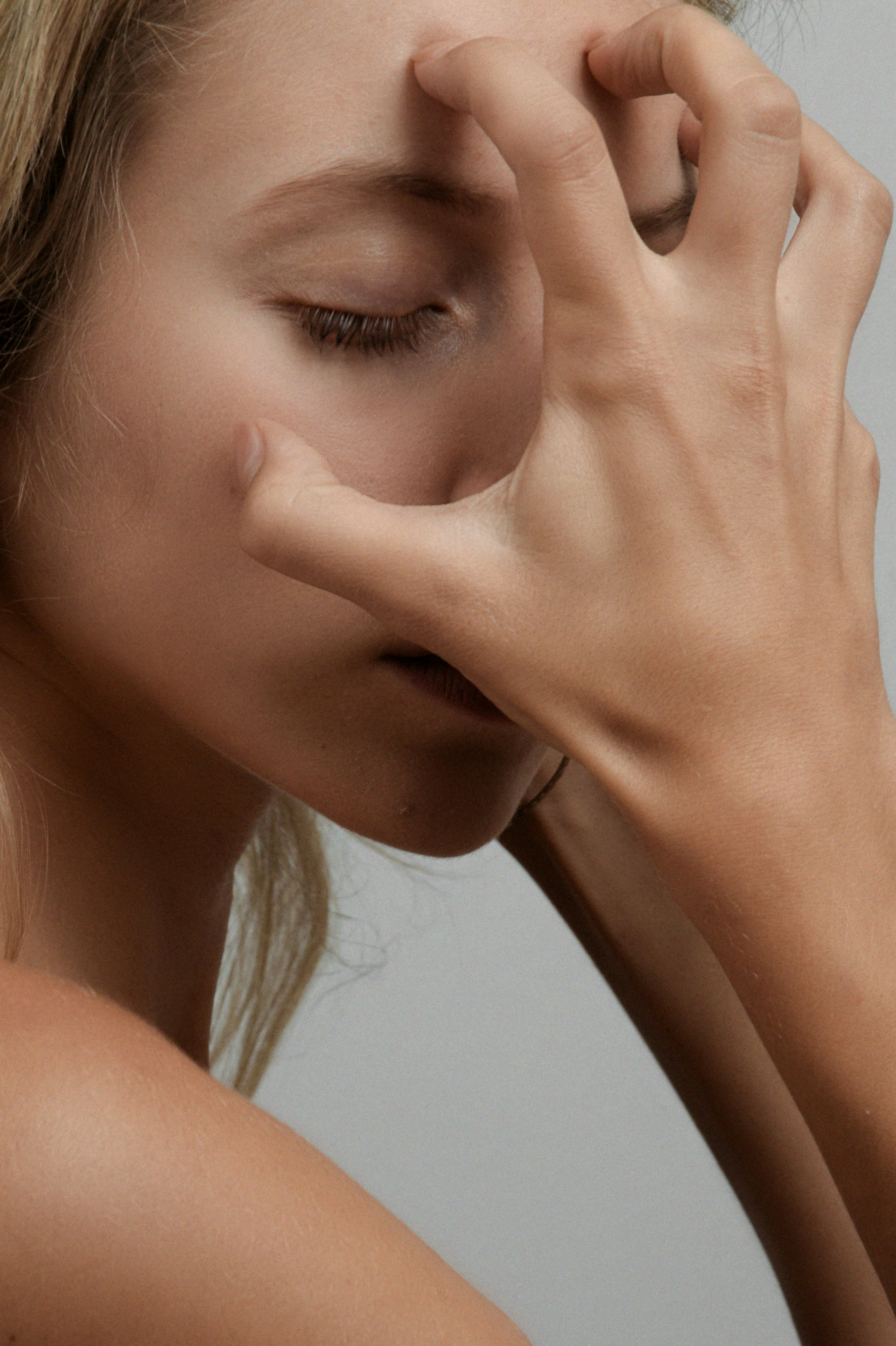 a woman holding her hand to her face