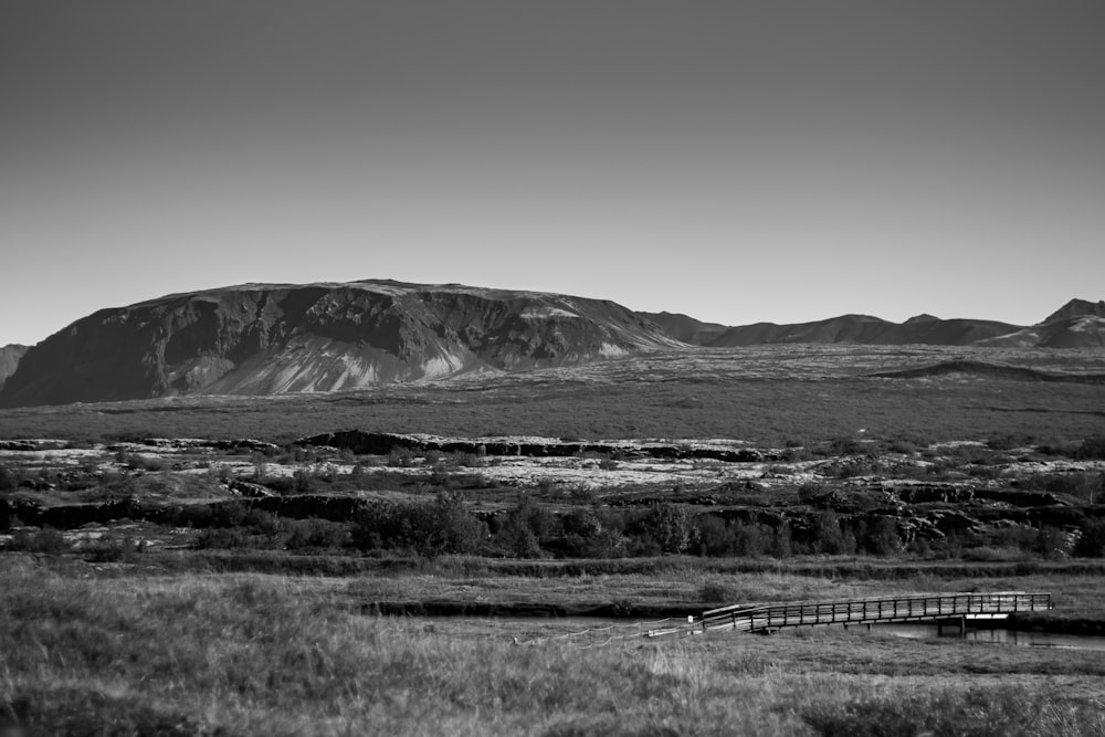 a black and white photo of mountains and a bridge