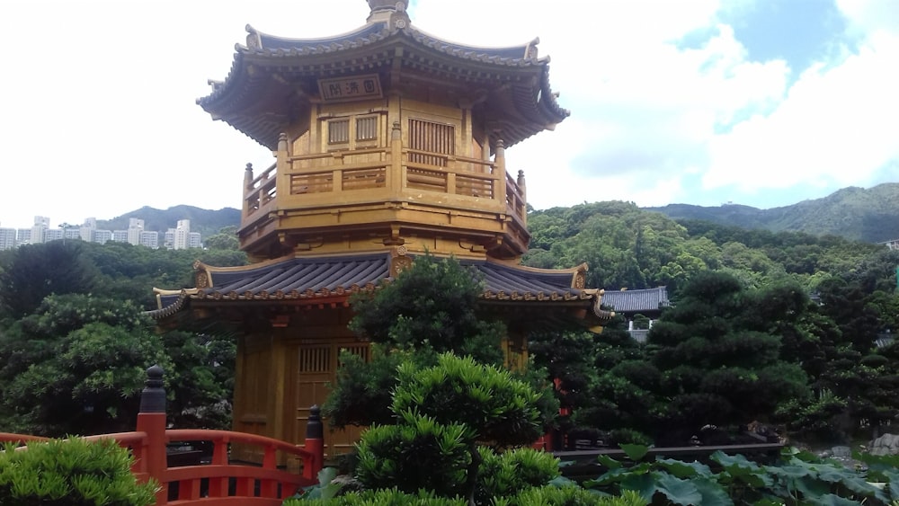 a tall yellow tower sitting next to a lush green forest