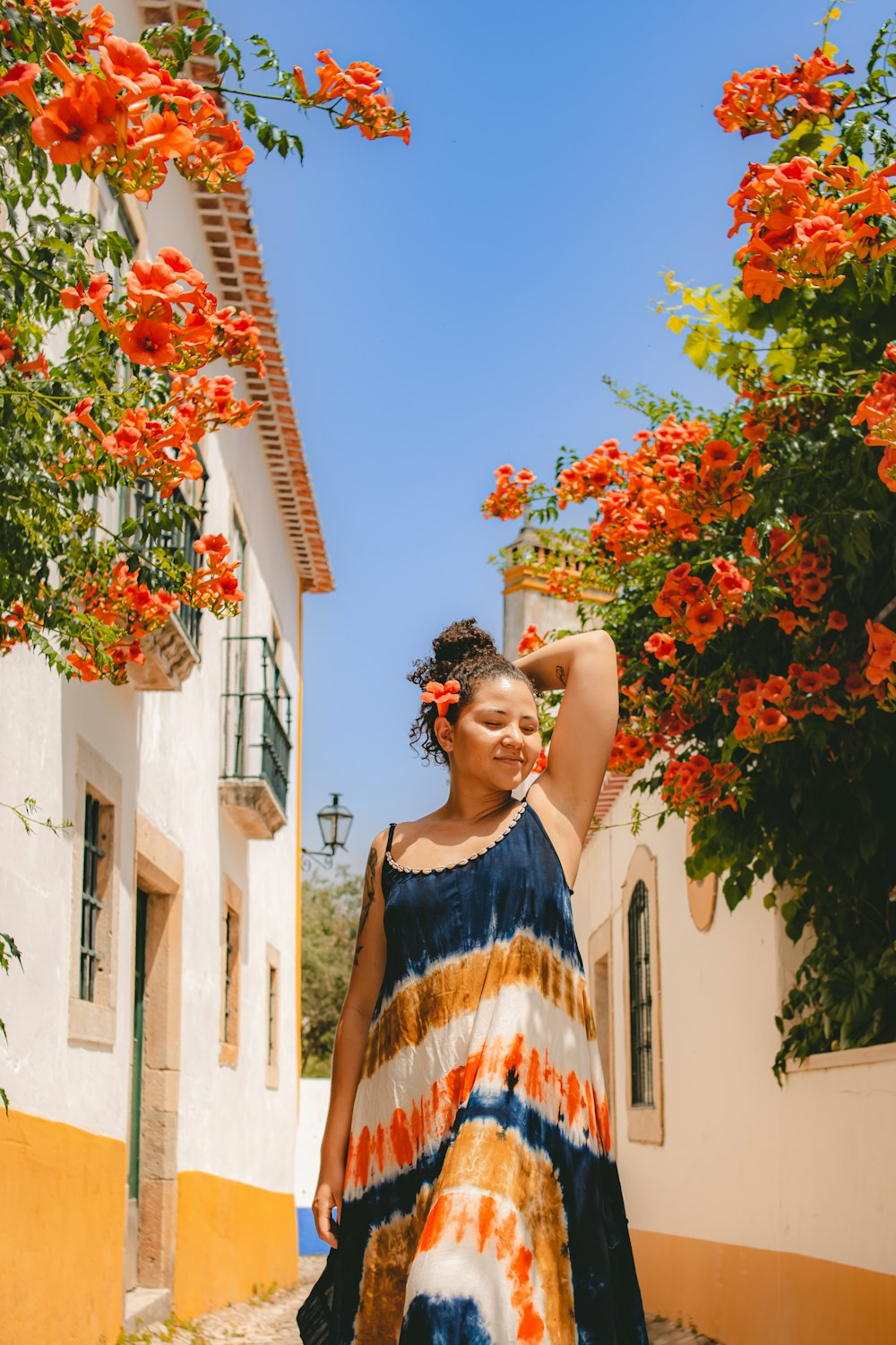 a woman in a colorful dress walking down a street