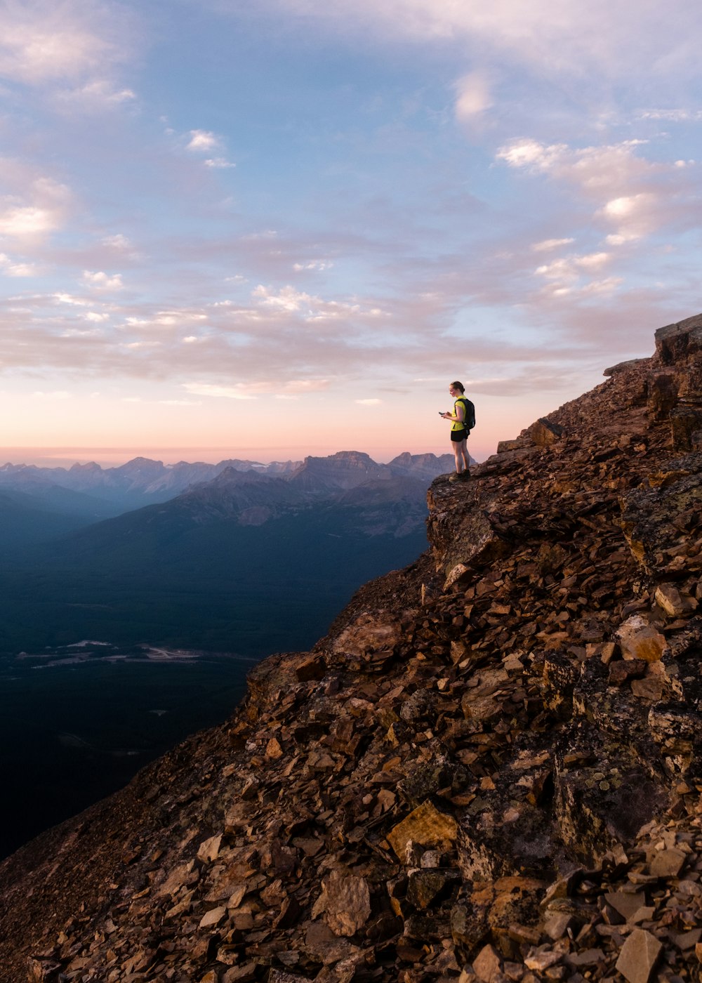 Un homme debout au sommet d’une montagne rocheuse