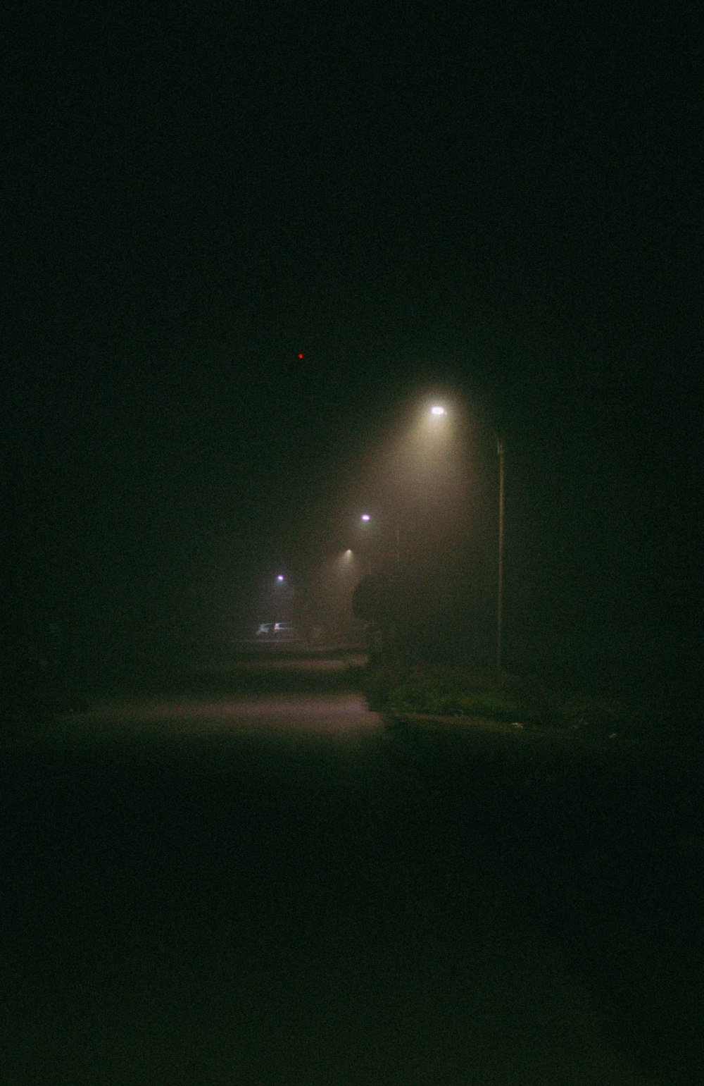 a dark street with street lights and a stop sign