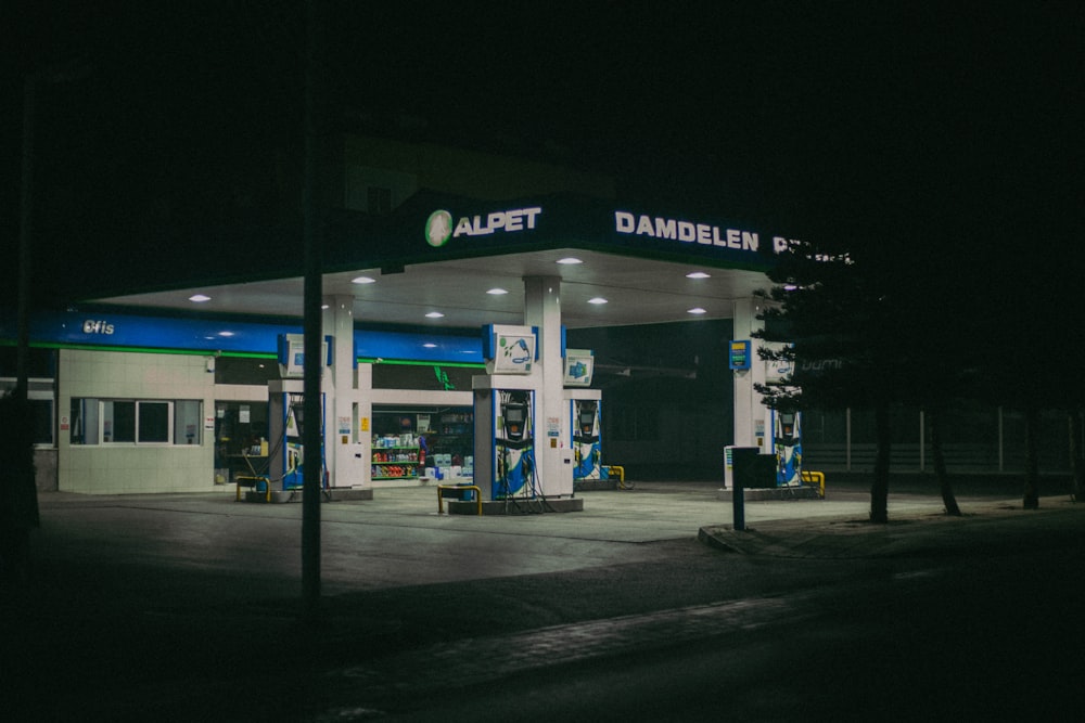 a gas station lit up at night time