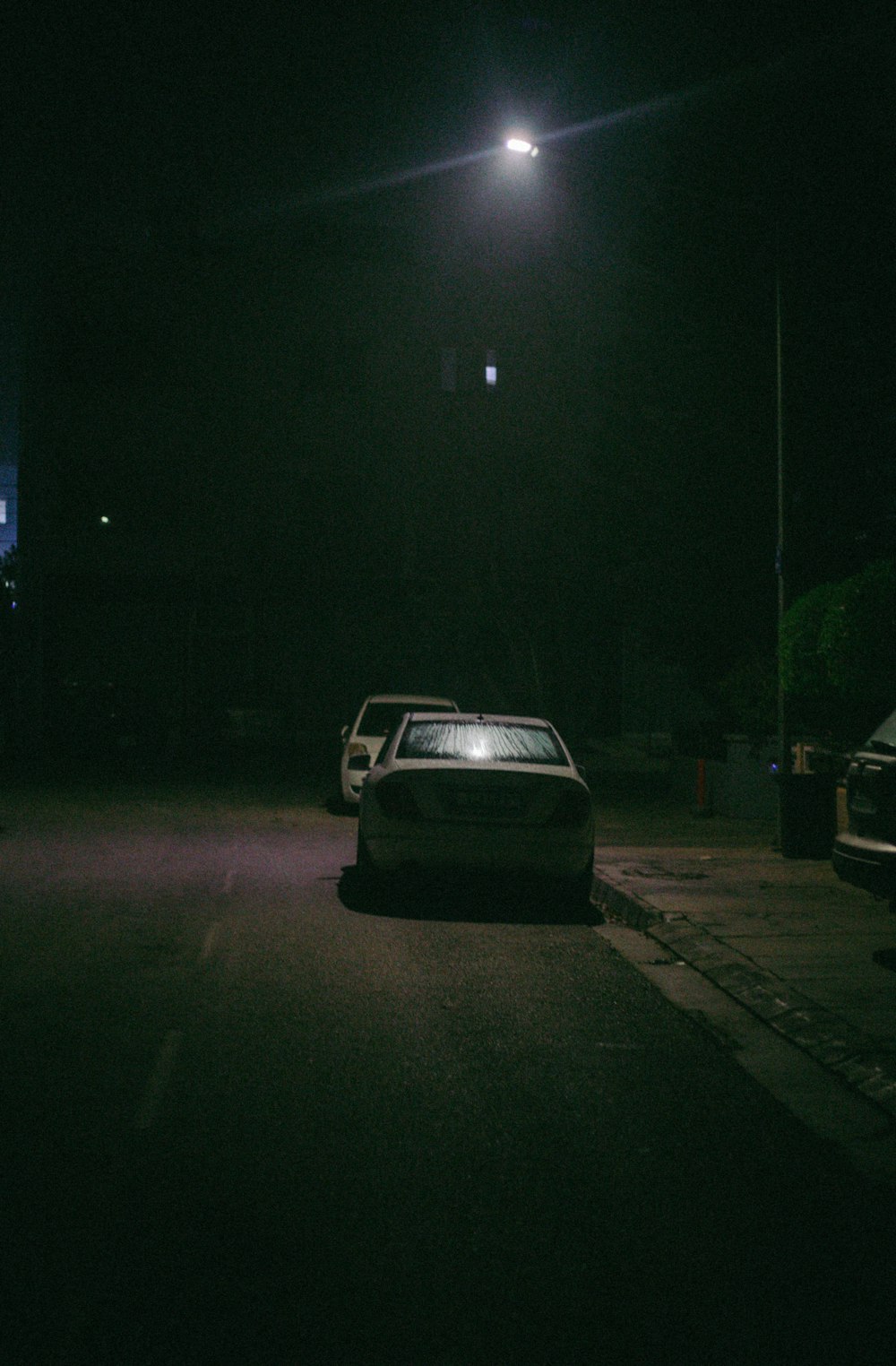 a car parked on the side of the road at night