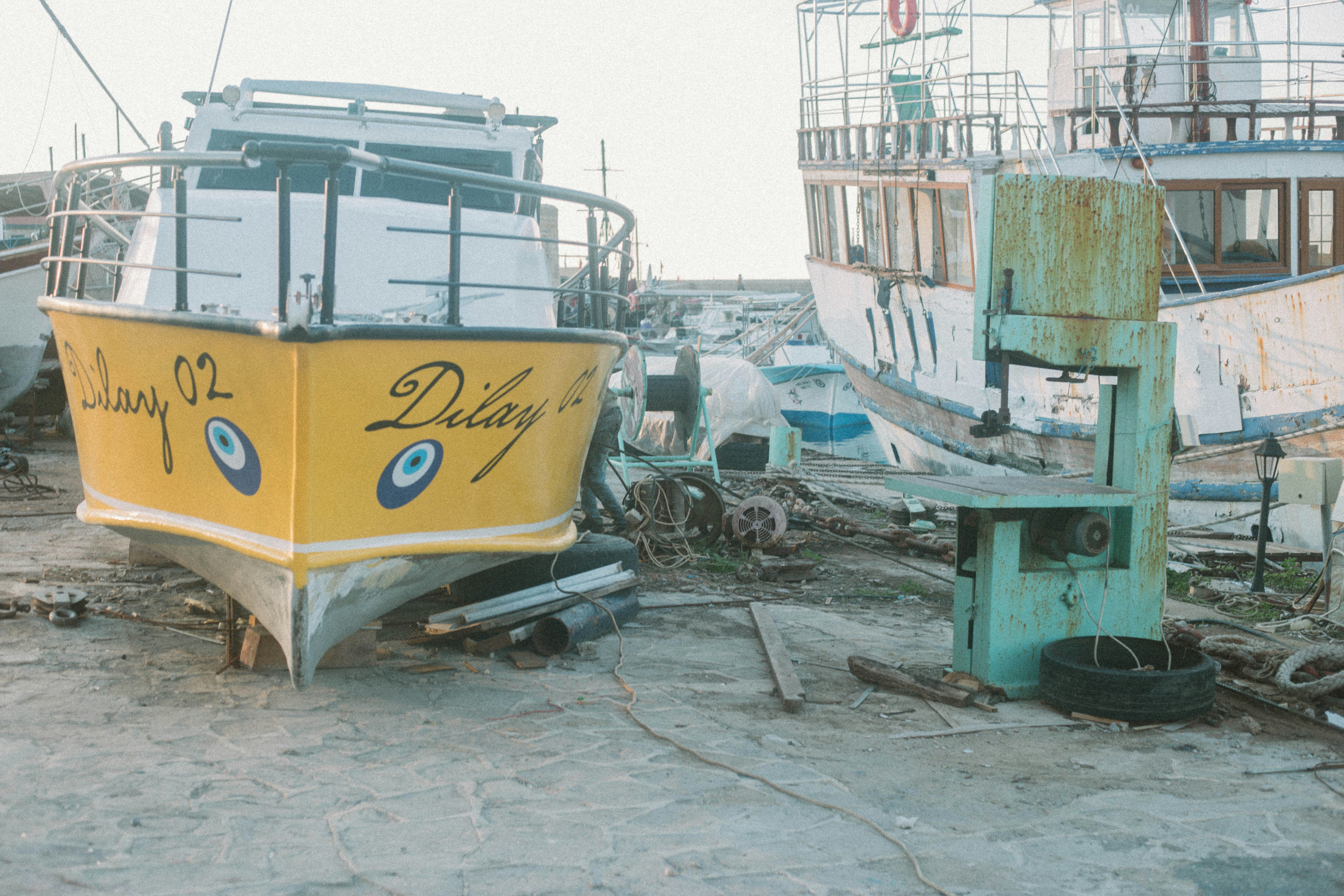 a yellow boat sitting on top of a sandy beach
