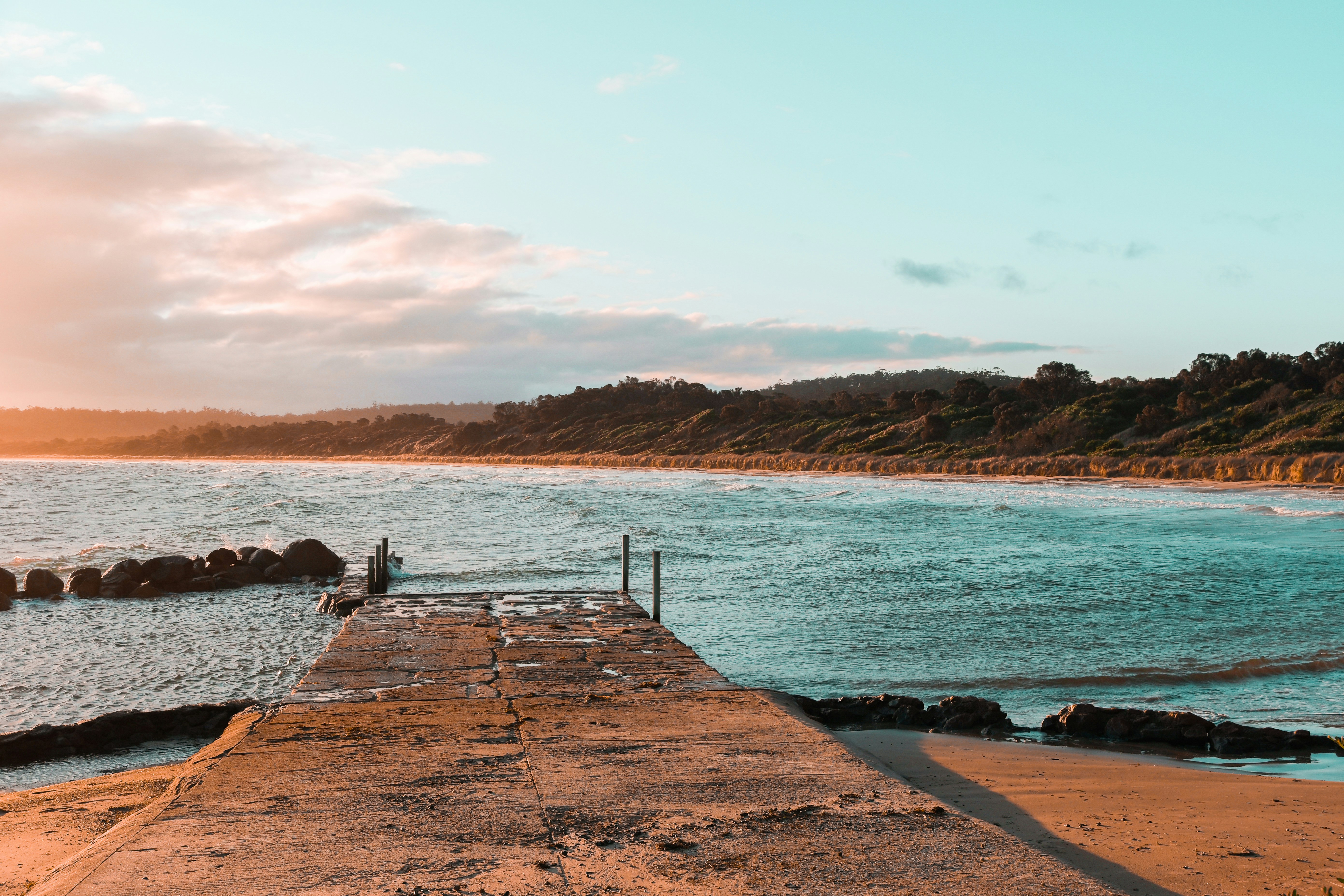 a person standing on a dock near the ocean