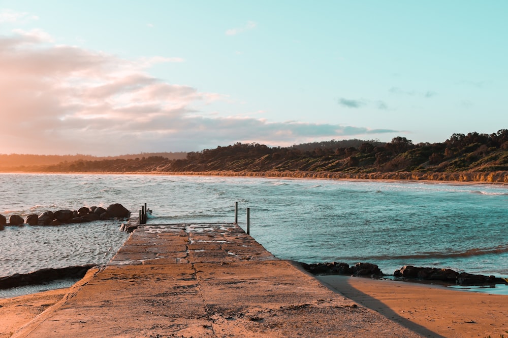 a person standing on a dock near the ocean