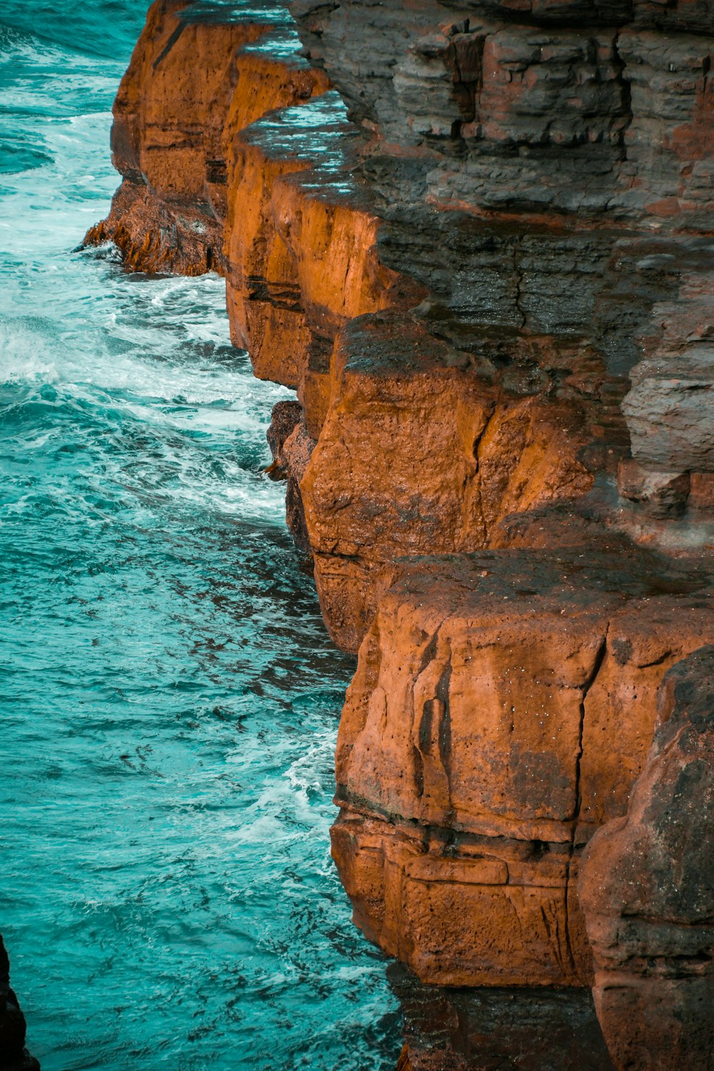 a man standing on a cliff next to the ocean