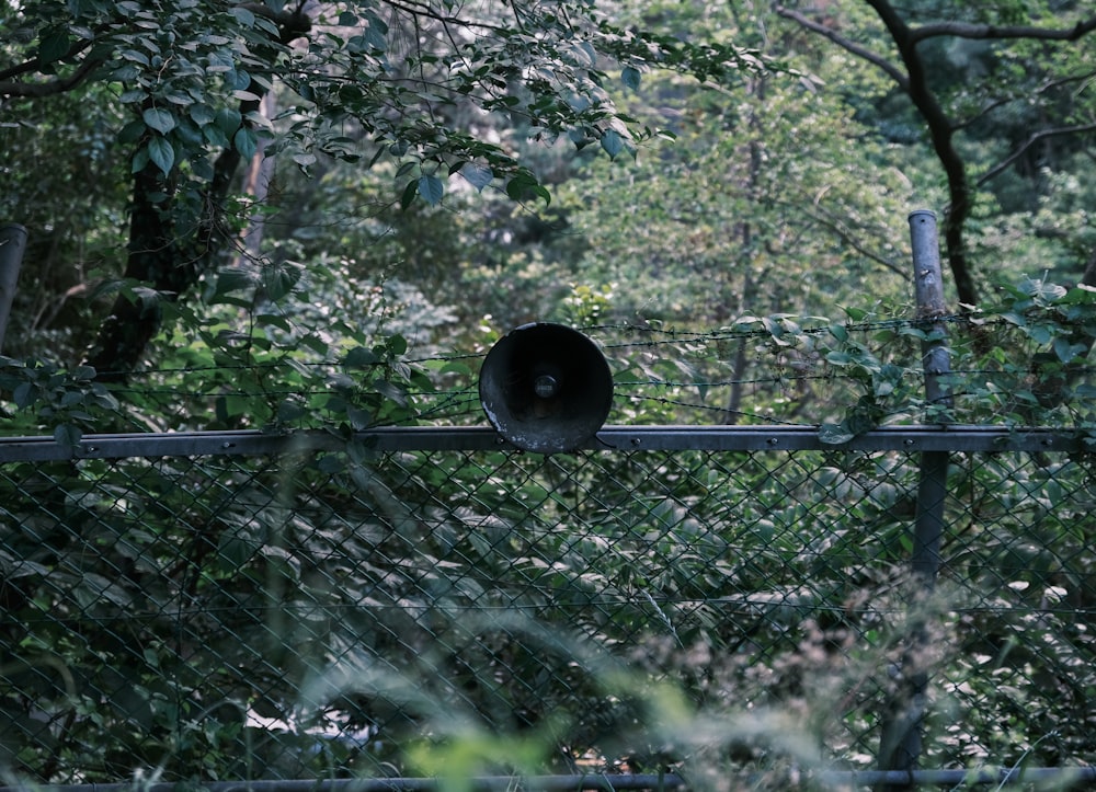 a black pipe sticking out of the side of a fence