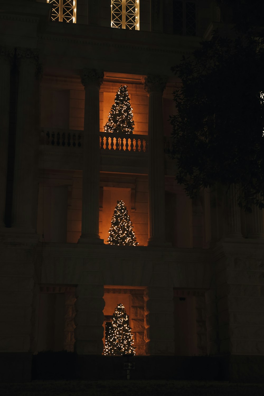 a lit up christmas tree in front of a building