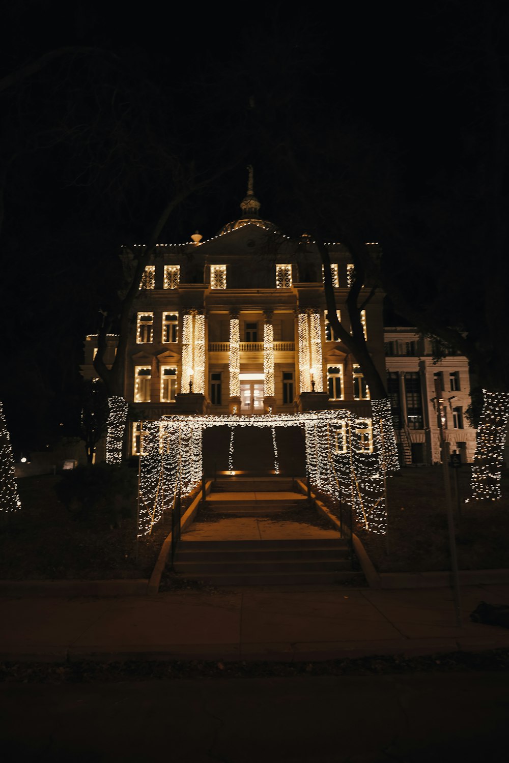 a large house covered in christmas lights at night