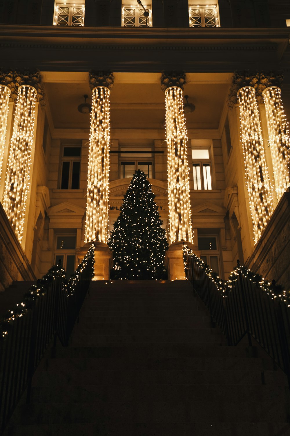 a lit christmas tree in front of a building