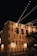 String lights are hung across a night sky, illuminating a building facade with the large, bold text 'EVERYONE HAS A STORY WORTH TELLING'. The building is adorned with industrial-style architecture including staircases and lamps.