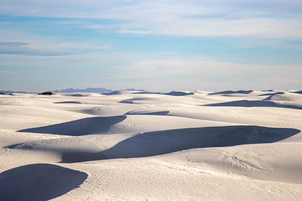 a vast expanse of white sand dunes under a blue sky