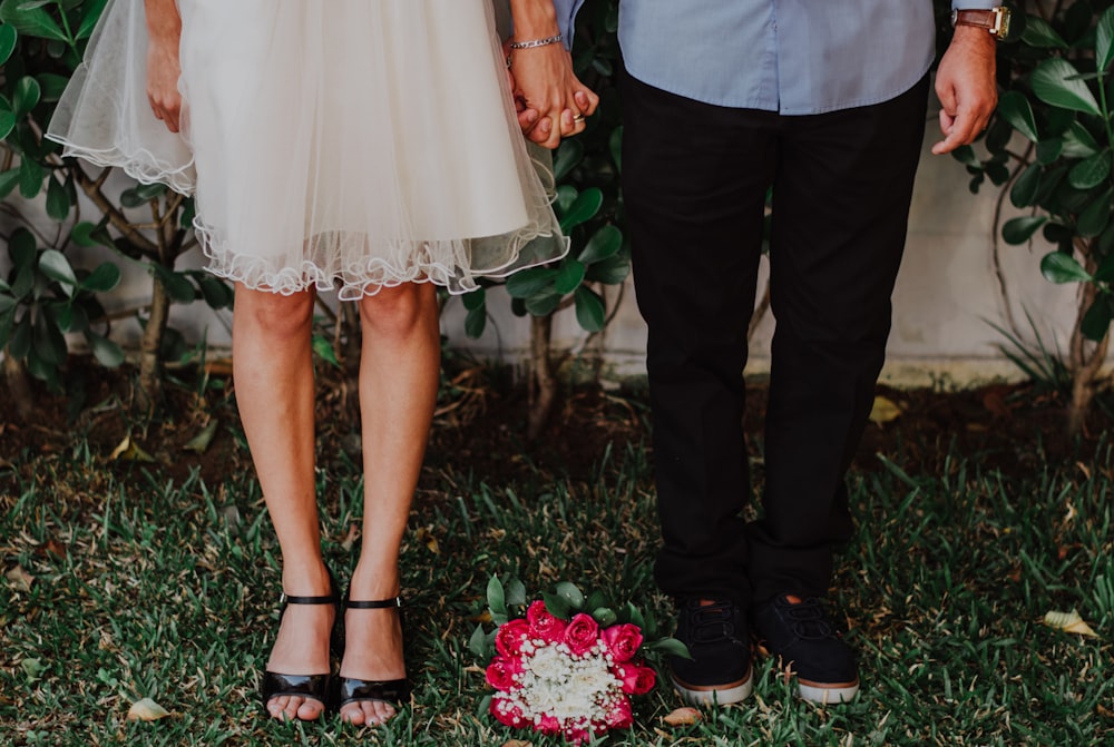 a man and woman holding hands standing next to each other