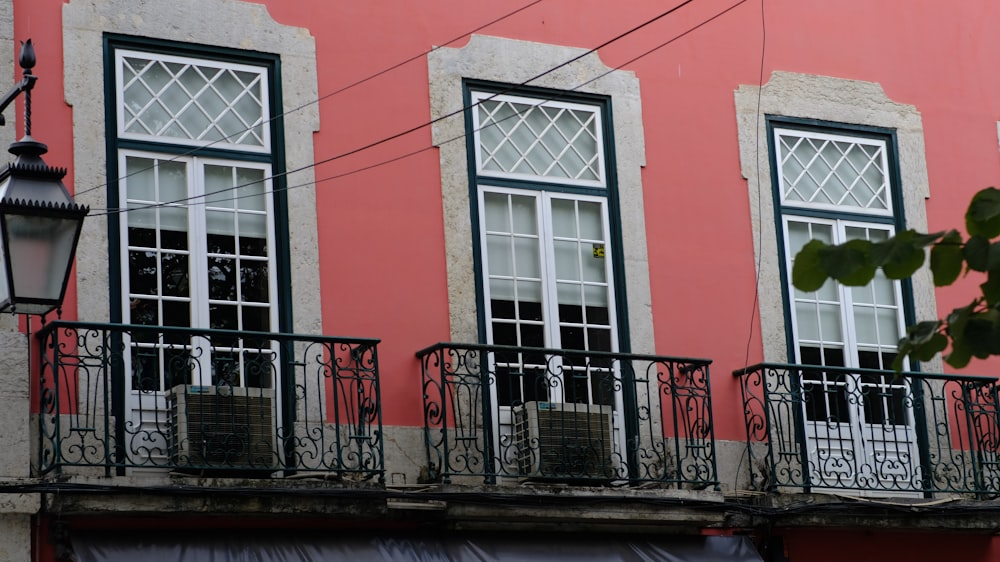 a red building with three windows and a balcony