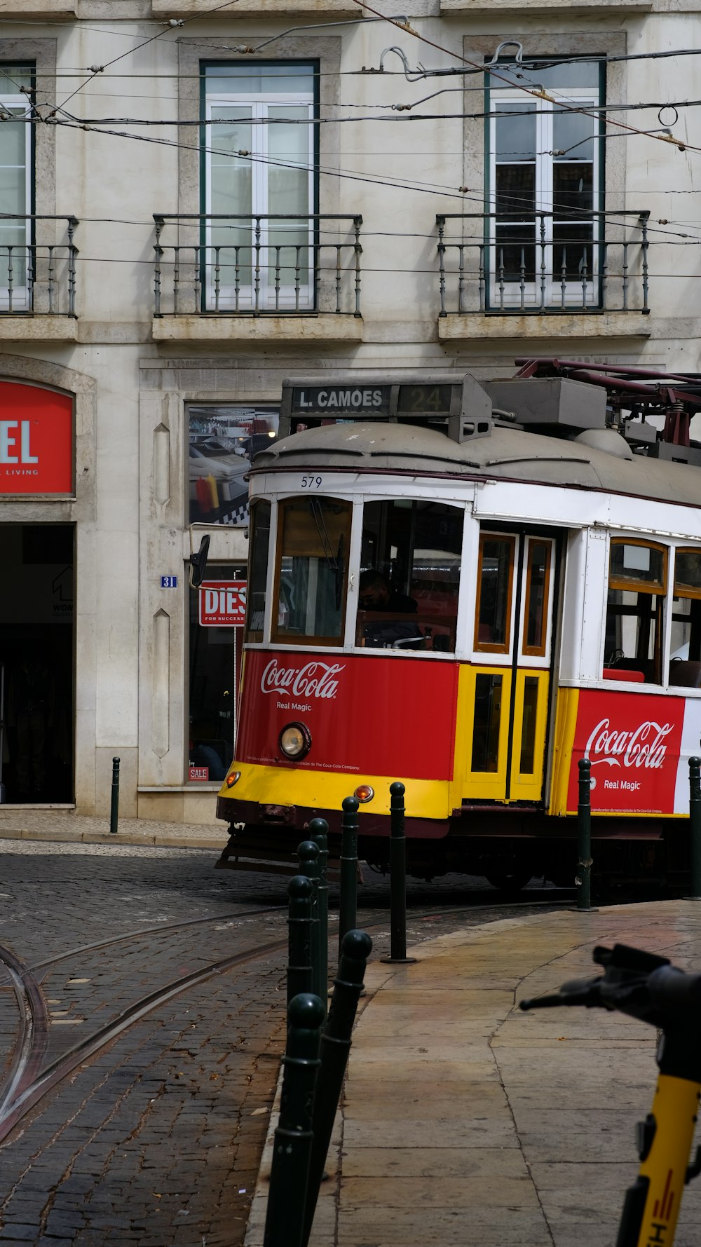 a red and yellow trolley on a city street
