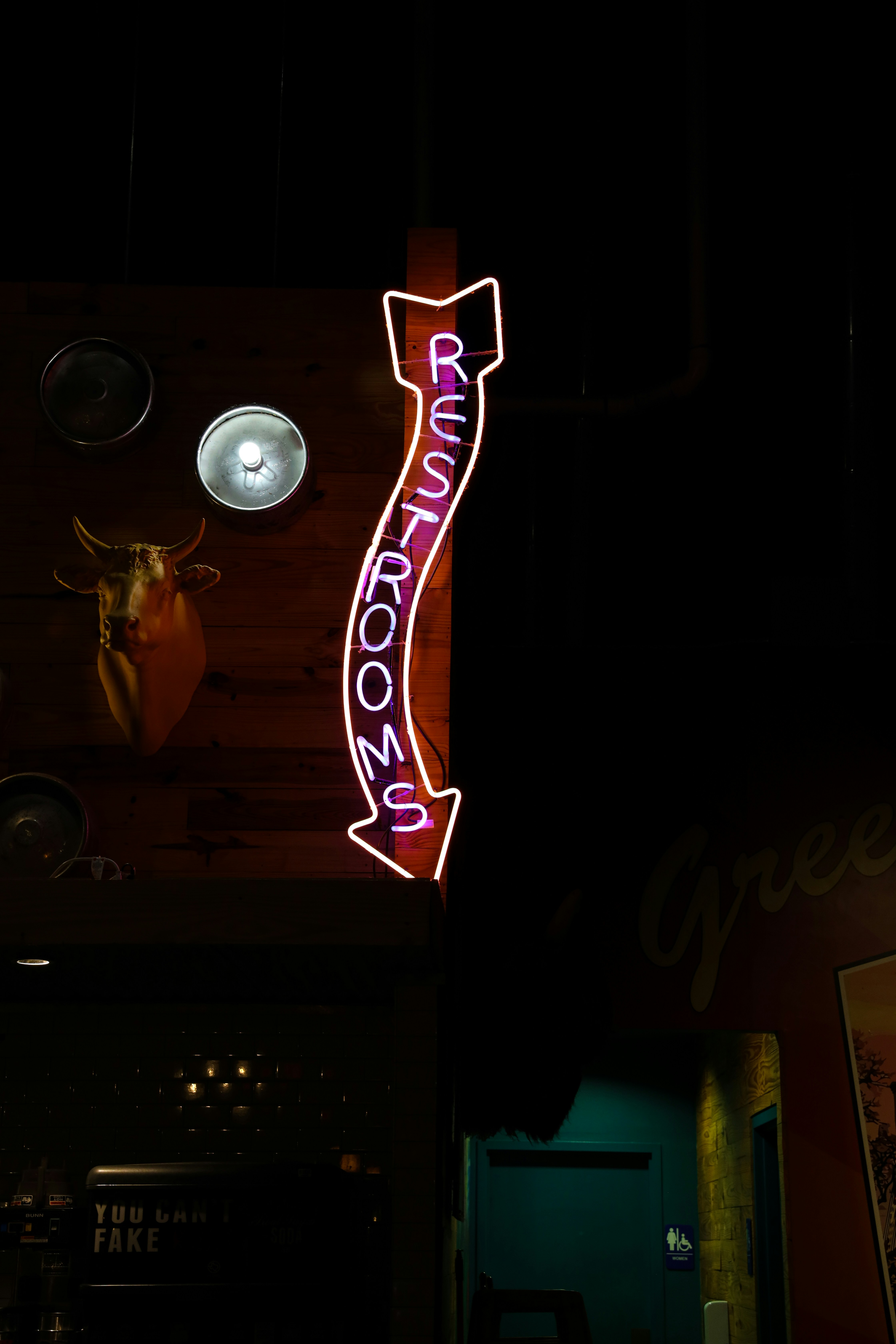 a neon sign hanging from the side of a building