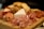 A charcuterie board displays an assortment of cured meats, including slices of prosciutto and salami, accompanied by wedges of cheese, crackers, and breadsticks. The items are neatly arranged on a wooden board, creating a rustic and inviting presentation.