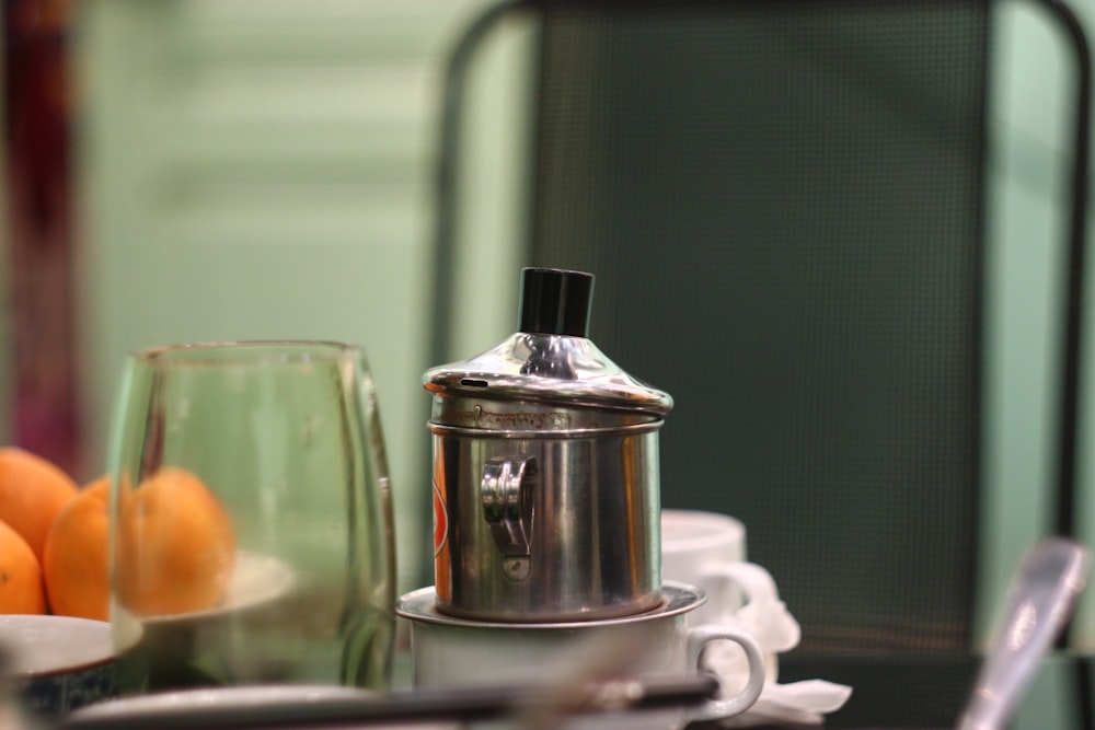 a silver coffee pot sitting on top of a table