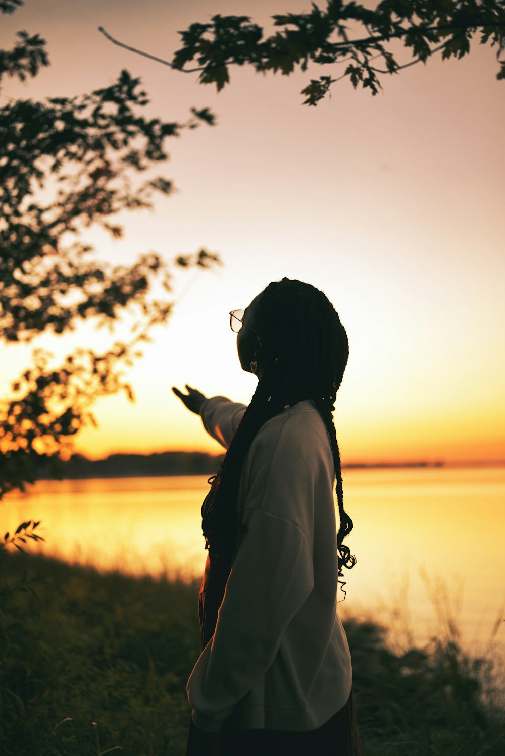 a woman standing in front of a body of water