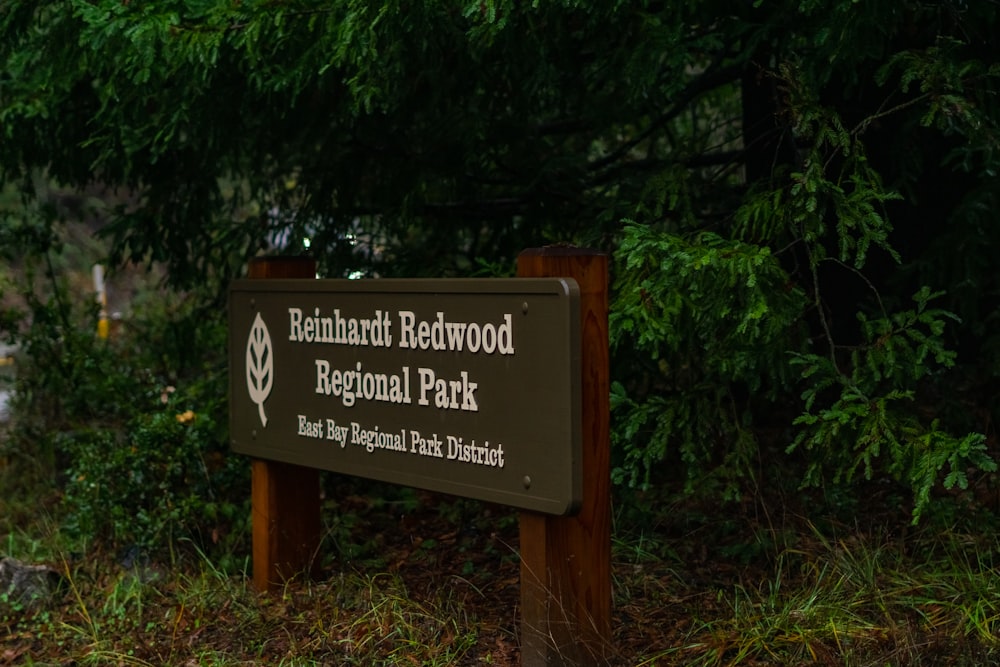 a sign in front of some trees and bushes