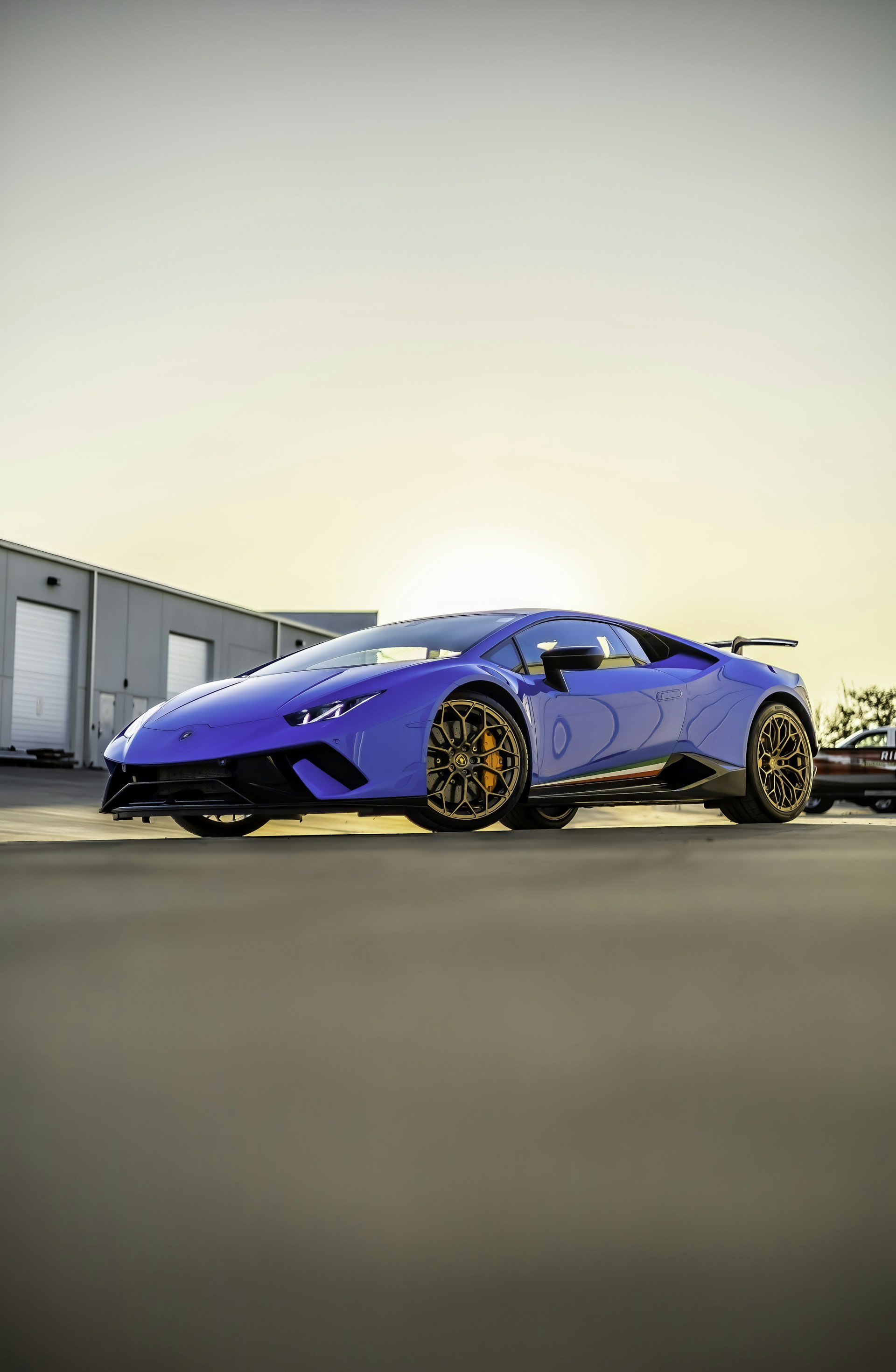 a blue sports car parked in front of a building