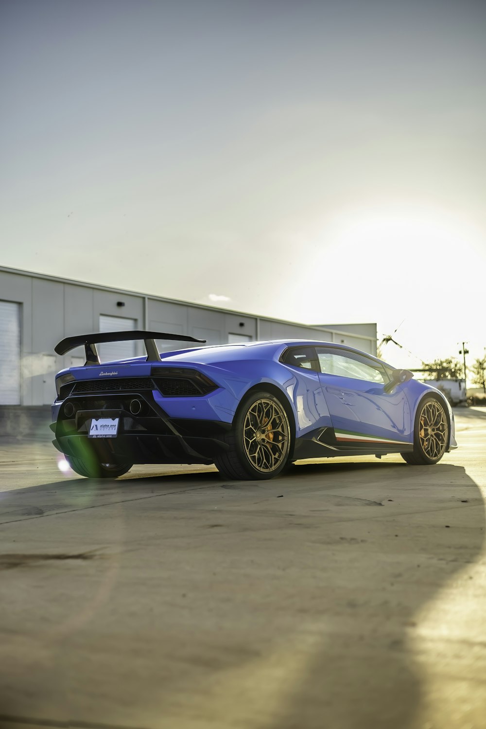 a blue sports car parked in front of a building