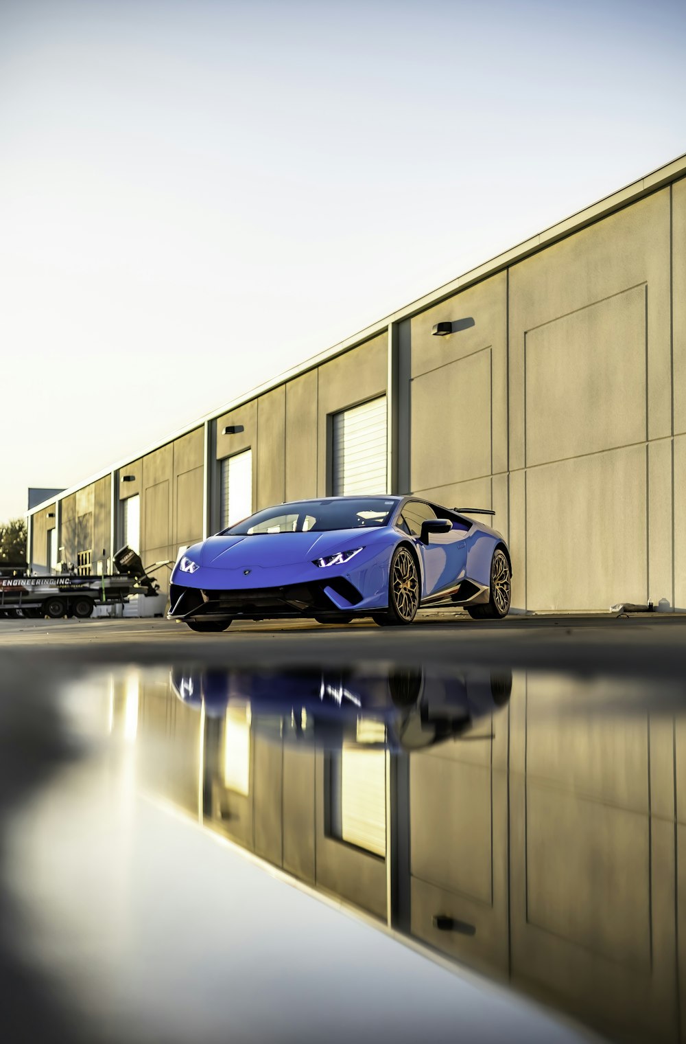 a blue sports car parked in front of a building