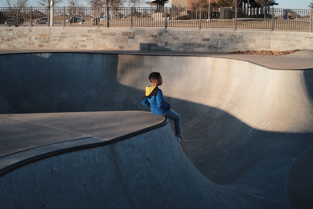 a young boy riding a skateboard up the side of a ramp