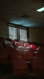 a row of red chairs sitting in front of a window