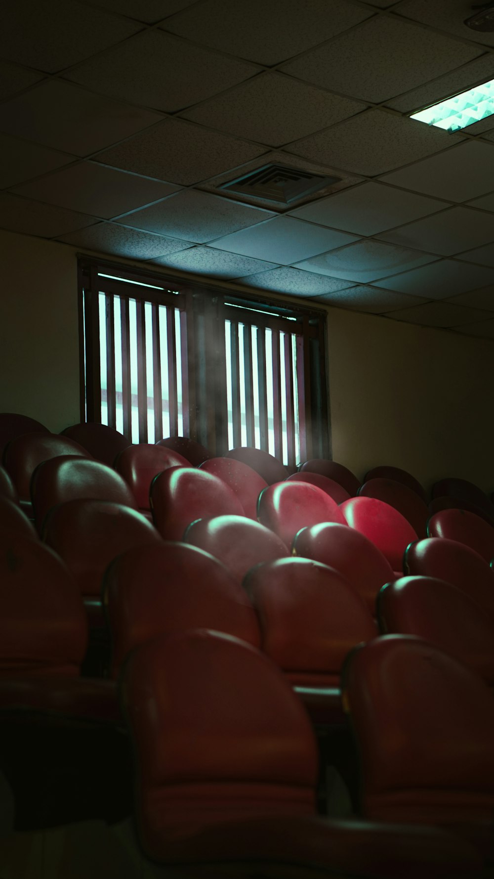 a row of red chairs sitting in front of a window