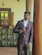 a man in a suit standing next to a pillar