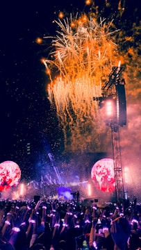 A vibrant outdoor concert with illuminated LED screens.