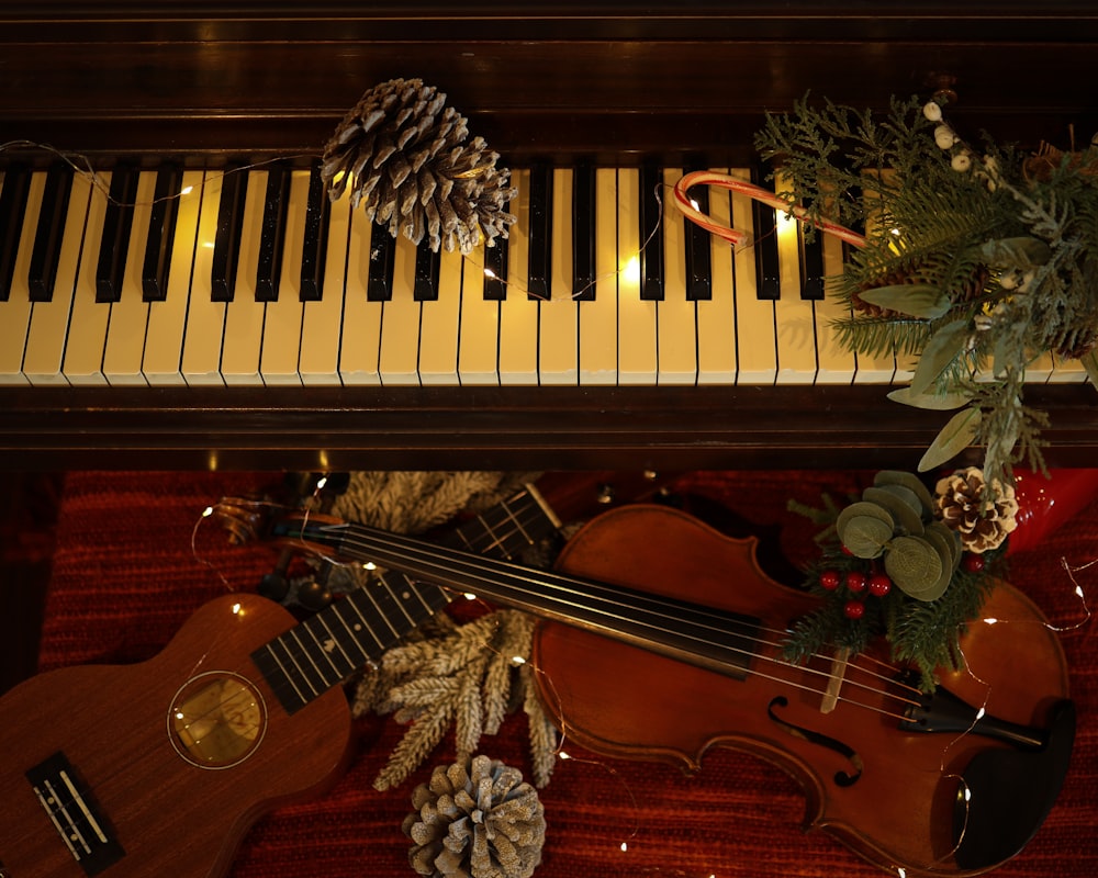 a violin and a pine cone sit on a piano