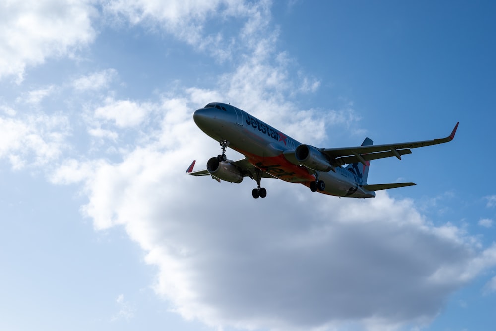 Un grande aereo di linea che vola attraverso un cielo blu nuvoloso