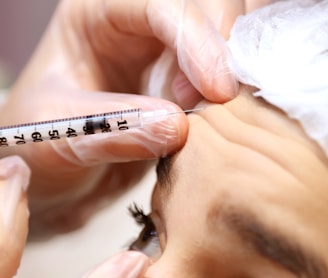a woman getting her eyebrows examined by a doctor