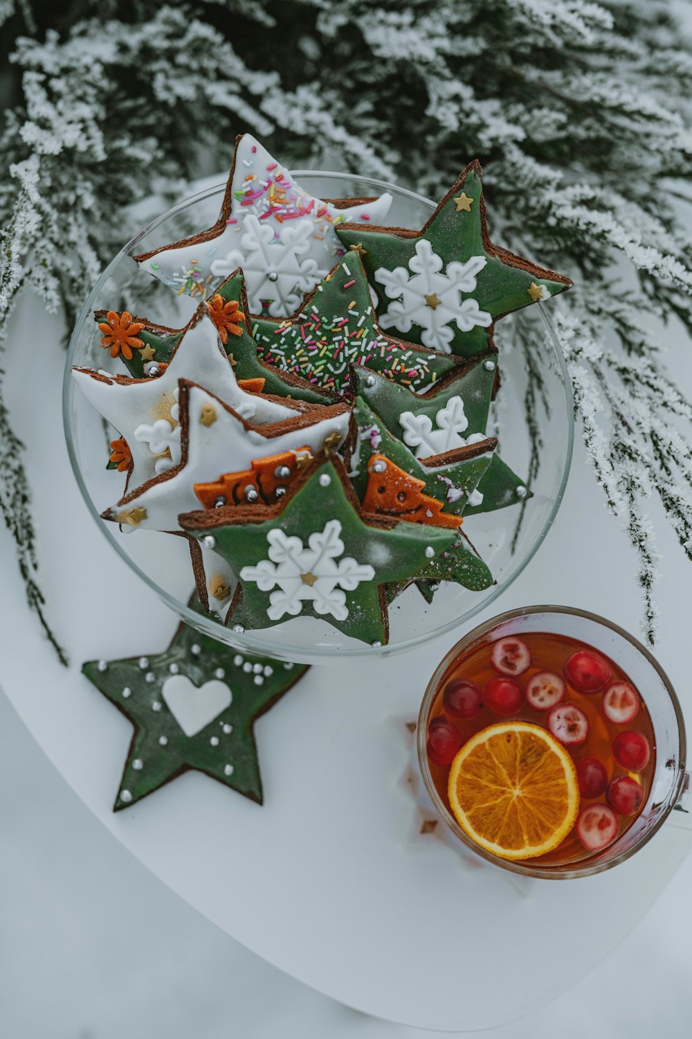 a plate of decorated cookies next to a cup of tea