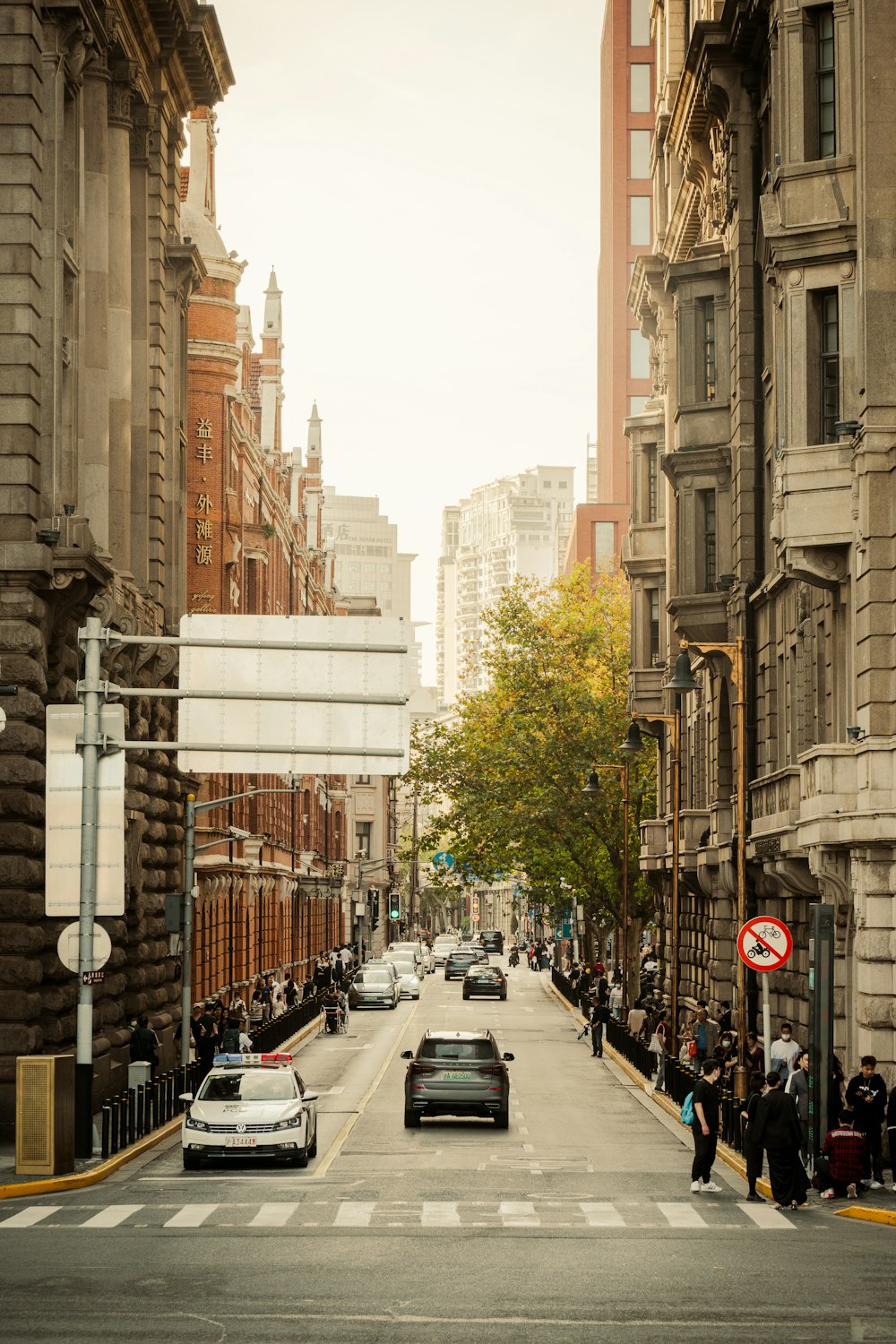 a city street filled with lots of traffic next to tall buildings