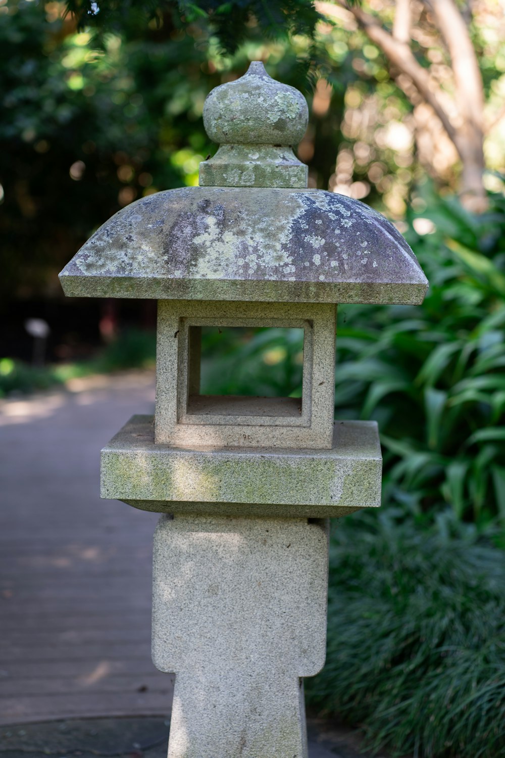 a stone lantern sitting on top of a sidewalk