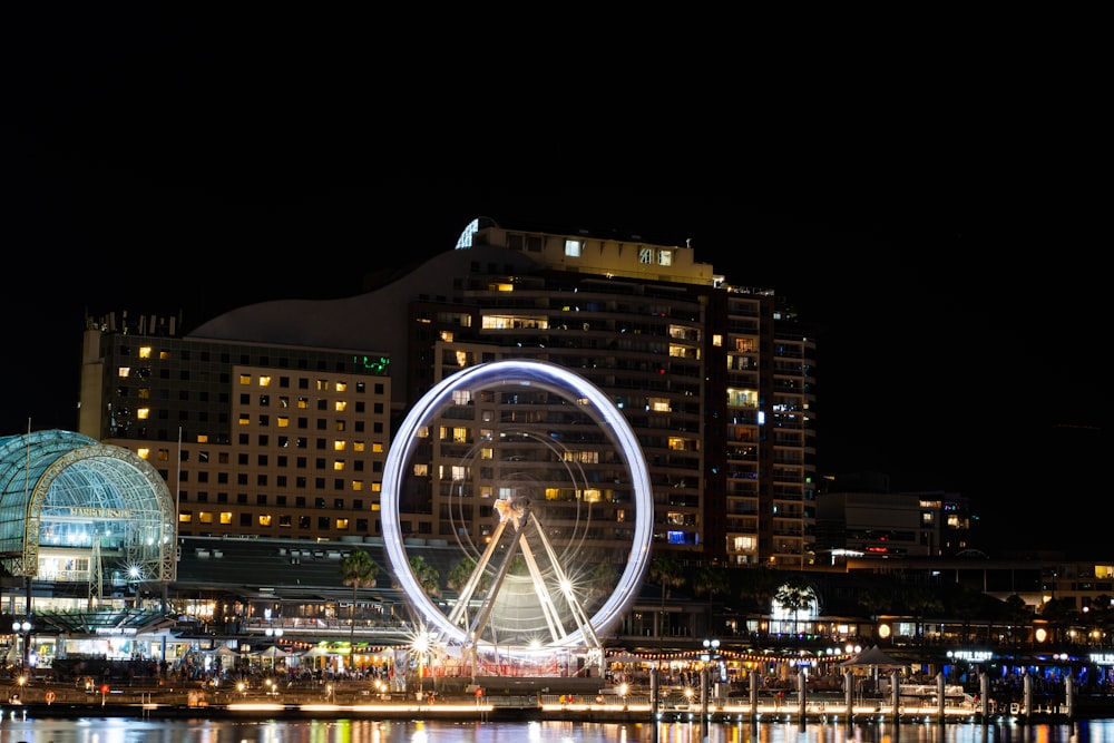 a ferris wheel in the middle of a city at night