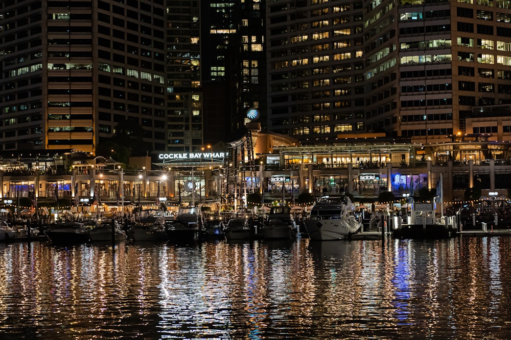 a harbor filled with lots of boats next to tall buildings