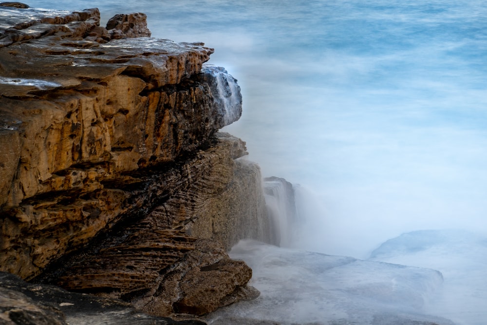 a large body of water next to a rocky cliff