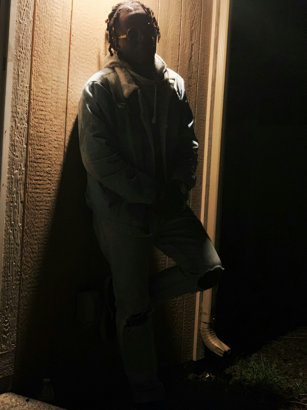 a man standing in front of a door in the dark