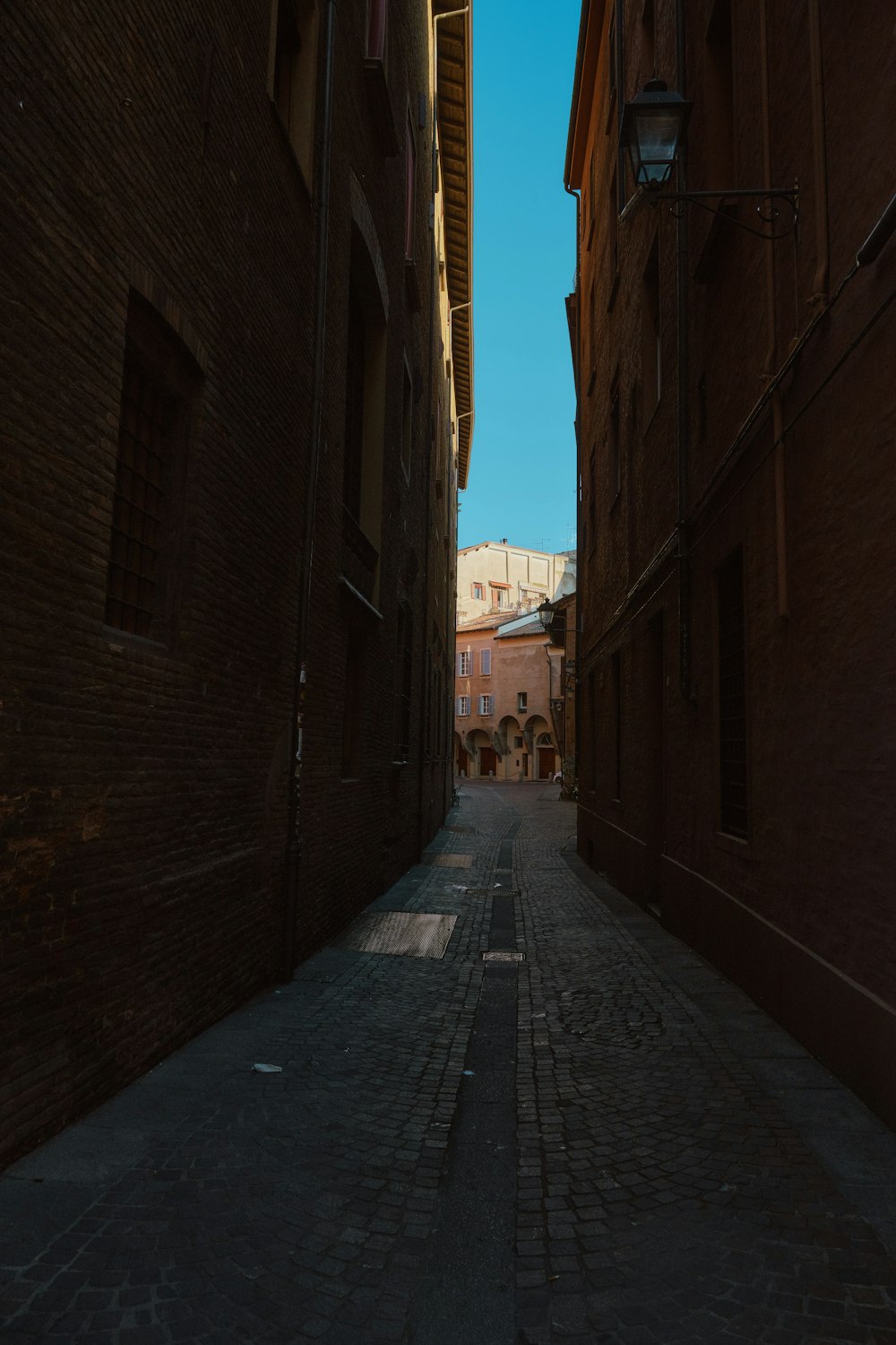 a narrow alley way with brick buildings on both sides