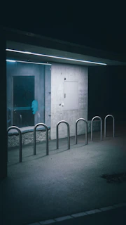 A minimalist urban art piece displayed on a concrete wall with subtle lighting.