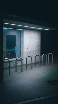 A minimalist urban art piece displayed on a concrete wall with subtle lighting.
