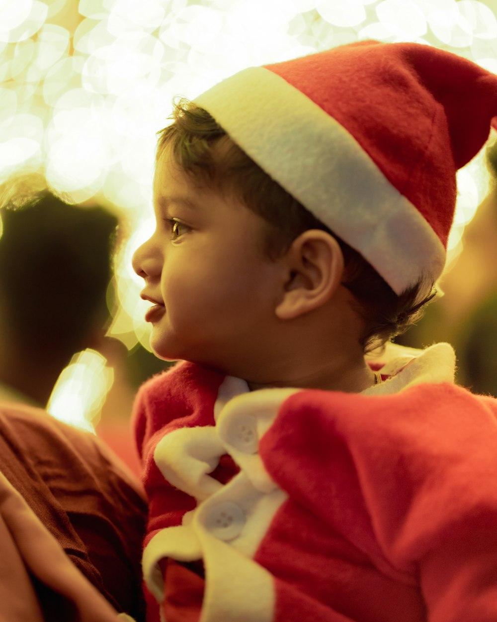 a small child wearing a santa hat and a red jacket