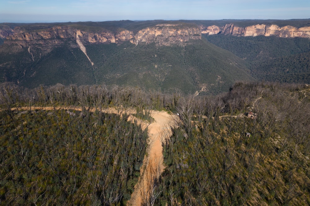 an aerial view of a dirt road in the mountains
